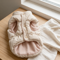 Load image into Gallery viewer, Chamonix Quilted Coat folded on a light oak surface beside a linen throw