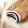 Load image into Gallery viewer, Close view of the Cortina Varsity Knit striped trim and crest