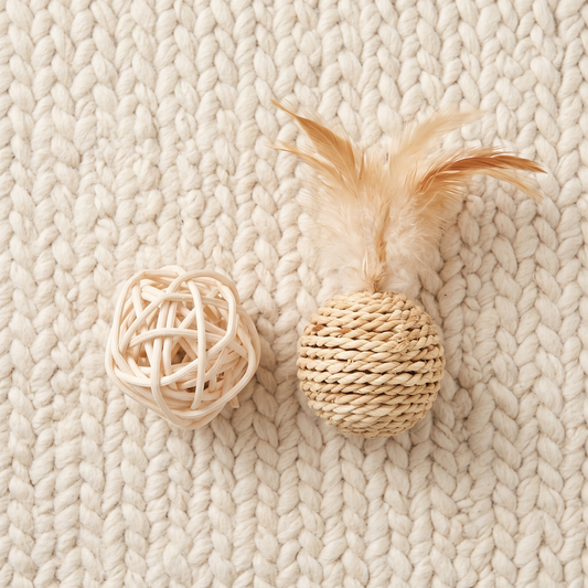Vimini rattan and sisal balls on a cream wool rug seen from above