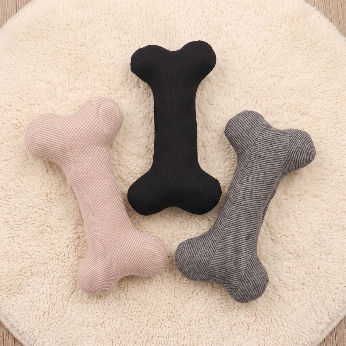 Spiga herringbone chew bones in pink, black and grey on a cream rug seen from above