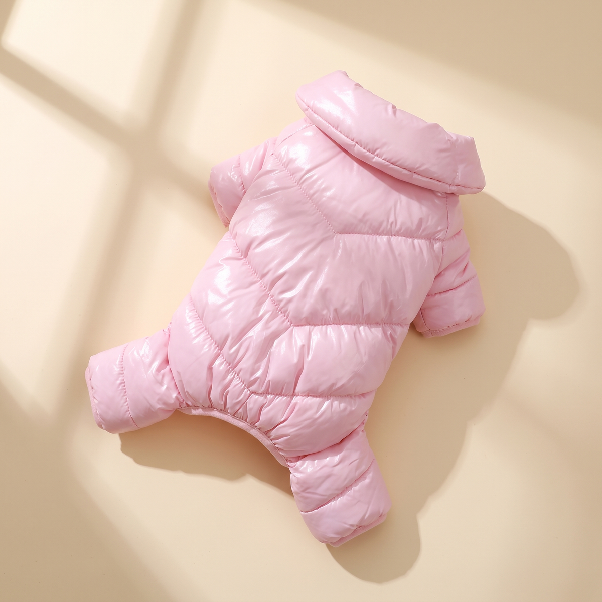 Verbier Puffer Suit in pink laid flat on a cream background
