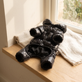 Load image into Gallery viewer, Verbier Puffer Suit in black on an oak window seat beside a linen throw
