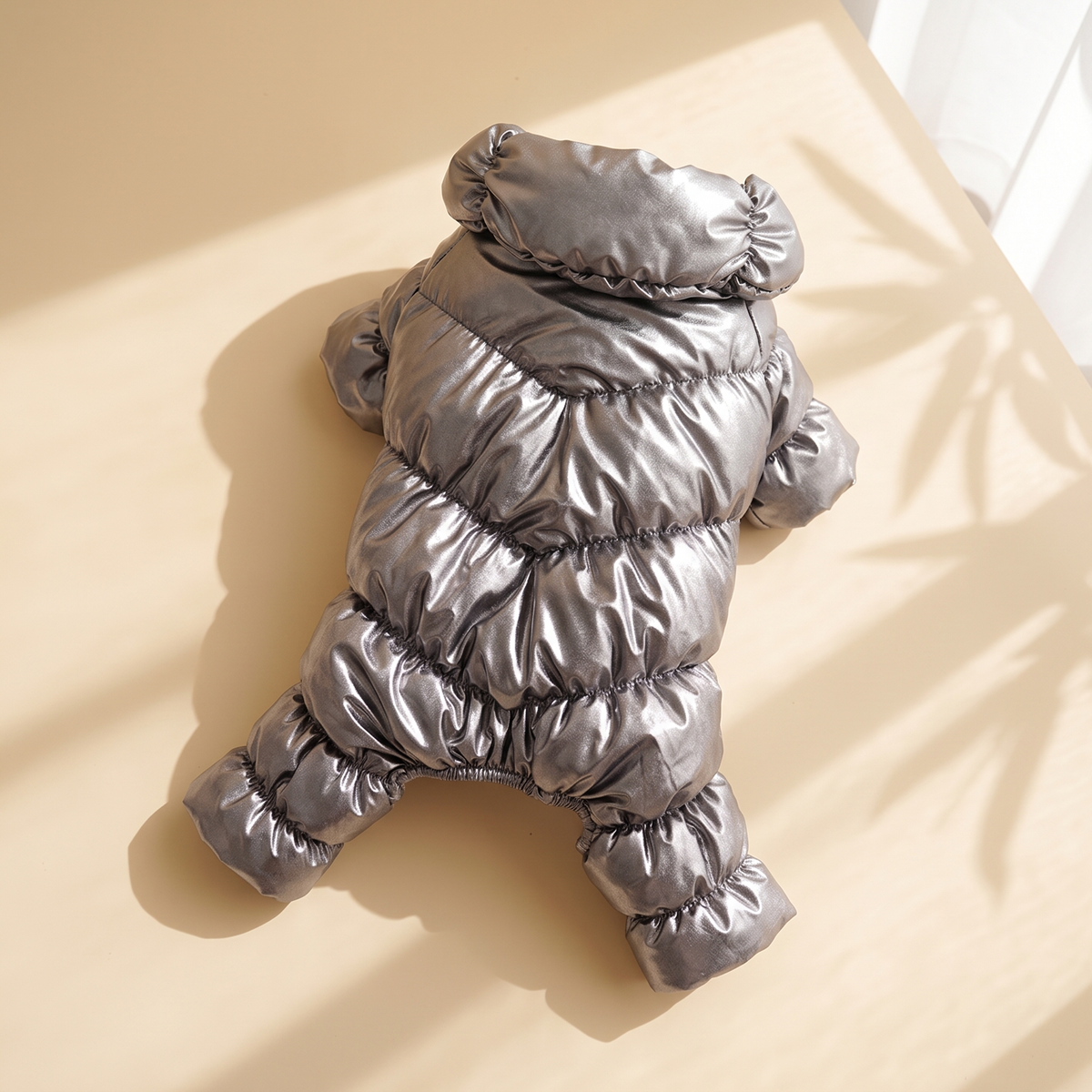 Verbier Puffer Suit in silver laid flat on a cream background
