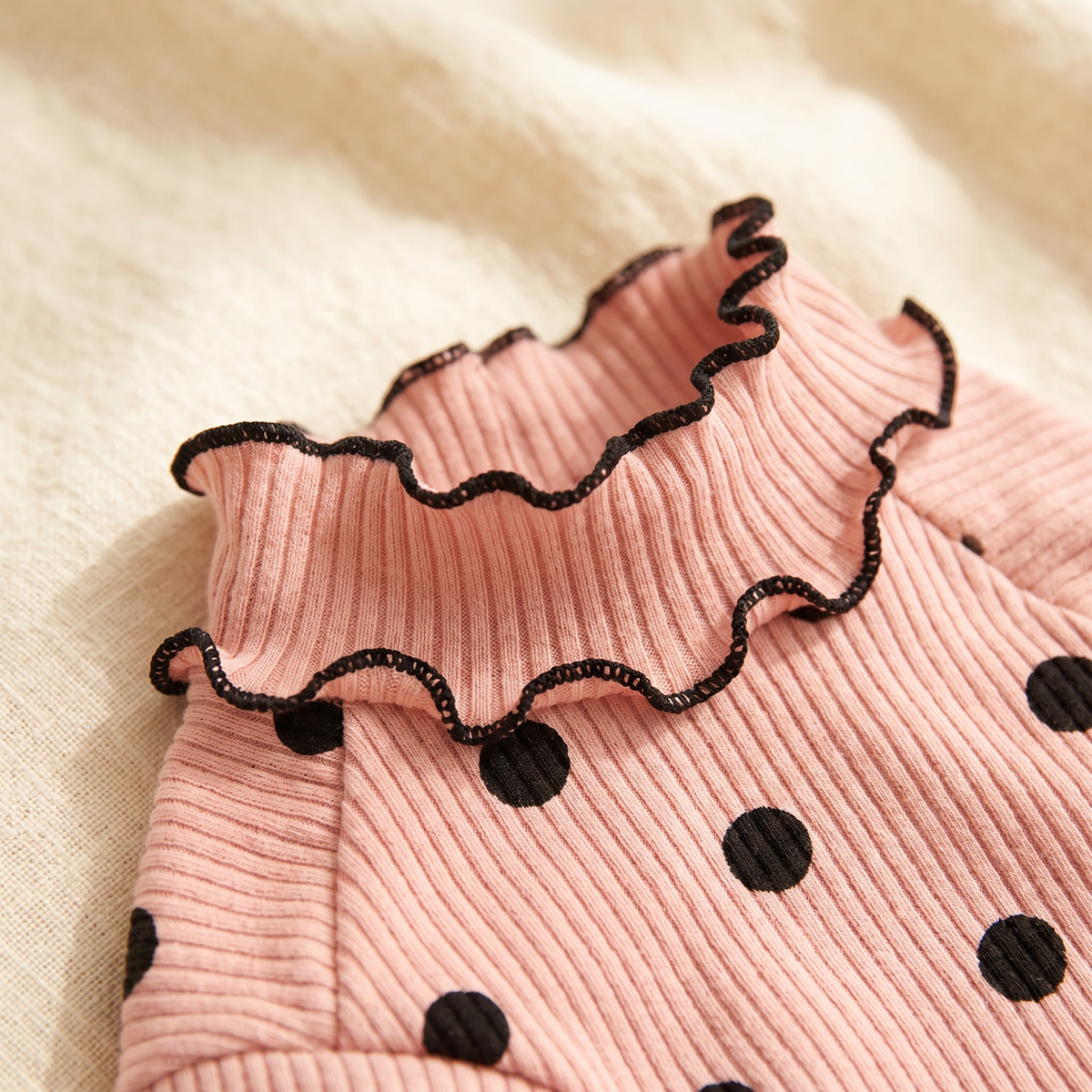 Close view of the Megève Dot Knit ruffled collar and ribbed knit