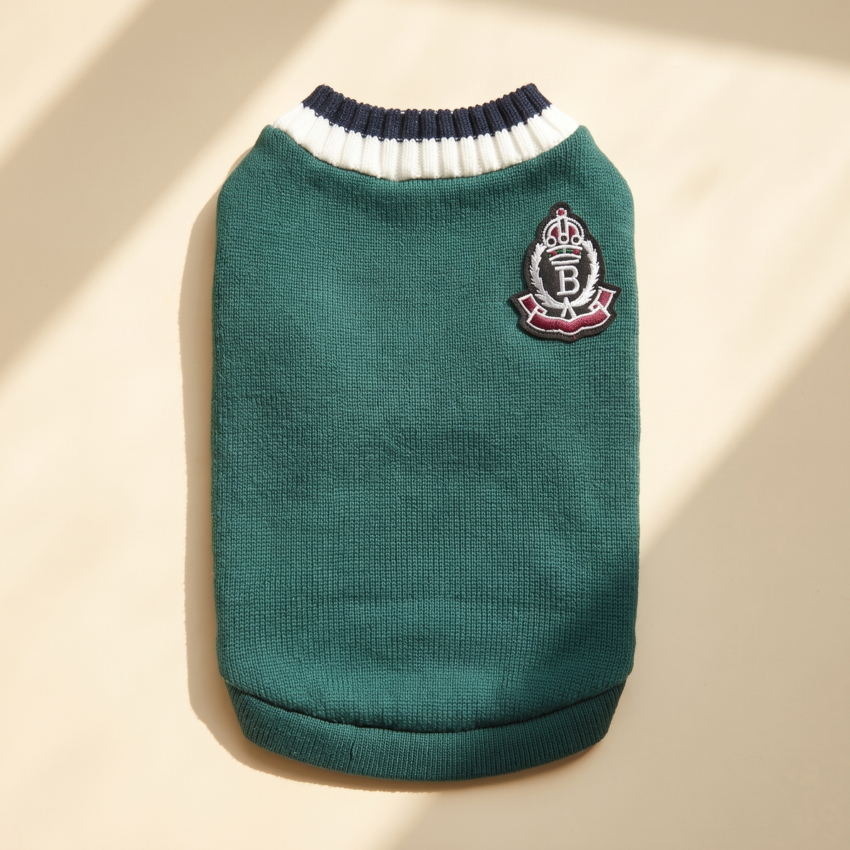 Cortina Varsity Knit in green laid flat on a cream background