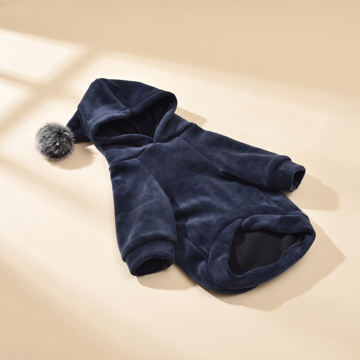 Gstaad Velour Hoodie in navy laid flat on a cream background