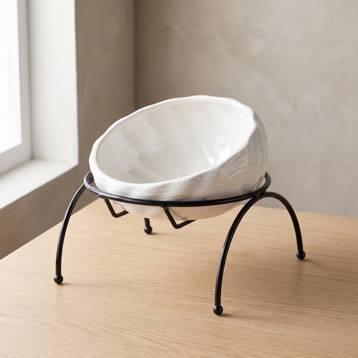 Onda Raised Bowl in White, tilted ceramic bowl on a black wire stand