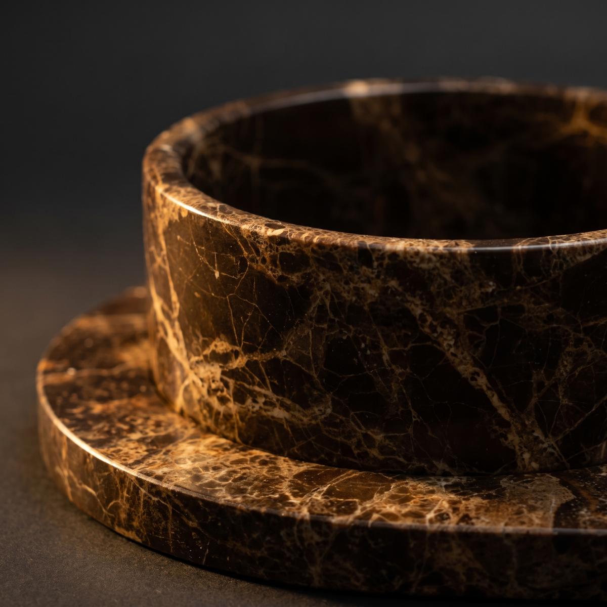 Close view of the dark Emperador marble rim, veined in cream and gold